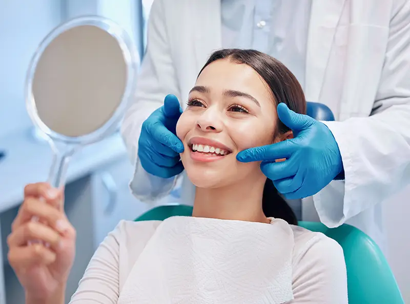 A women smiling while looking in the mirror